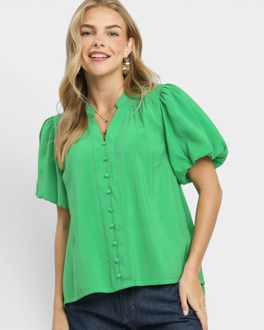 Woman wearing a green blouse with puff sleeves on a white background