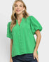 Woman wearing a green blouse with puff sleeves on a white background