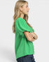Woman wearing a green blouse with puff sleeves on a white background
