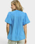 Woman wearing a blue blouse with puffed sleeves on a white background