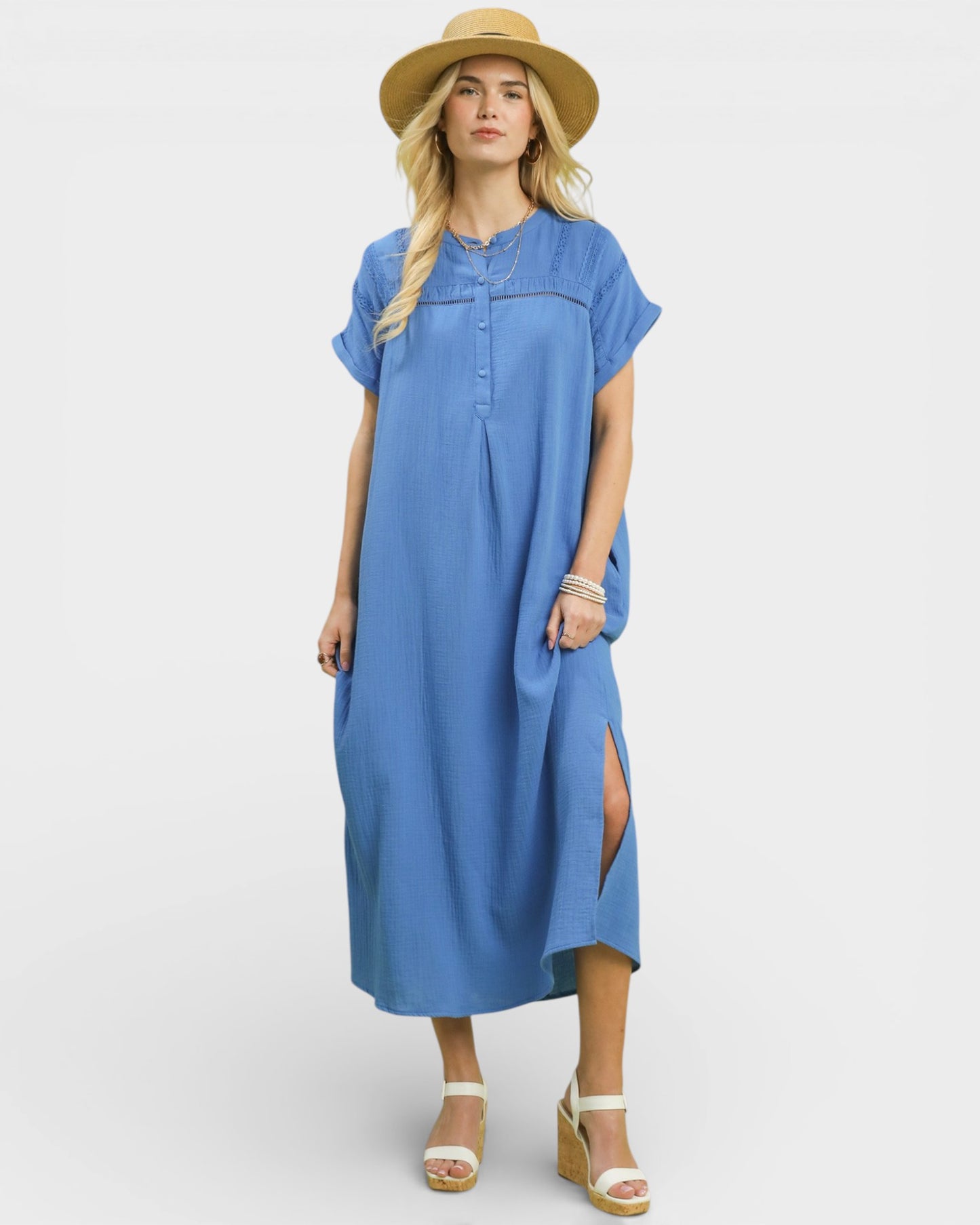 Woman wearing a blue dress with a straw hat on a white background