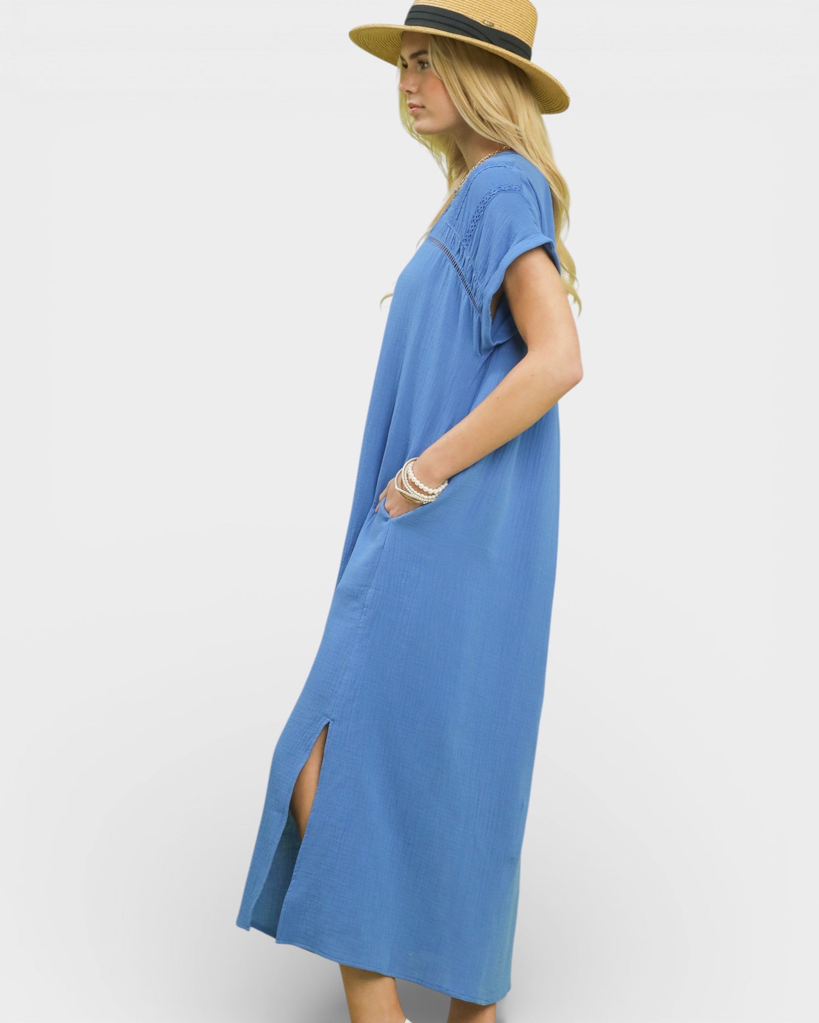 Woman wearing a blue dress and straw hat on a white background