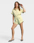 Woman wearing a light green romper on a white background