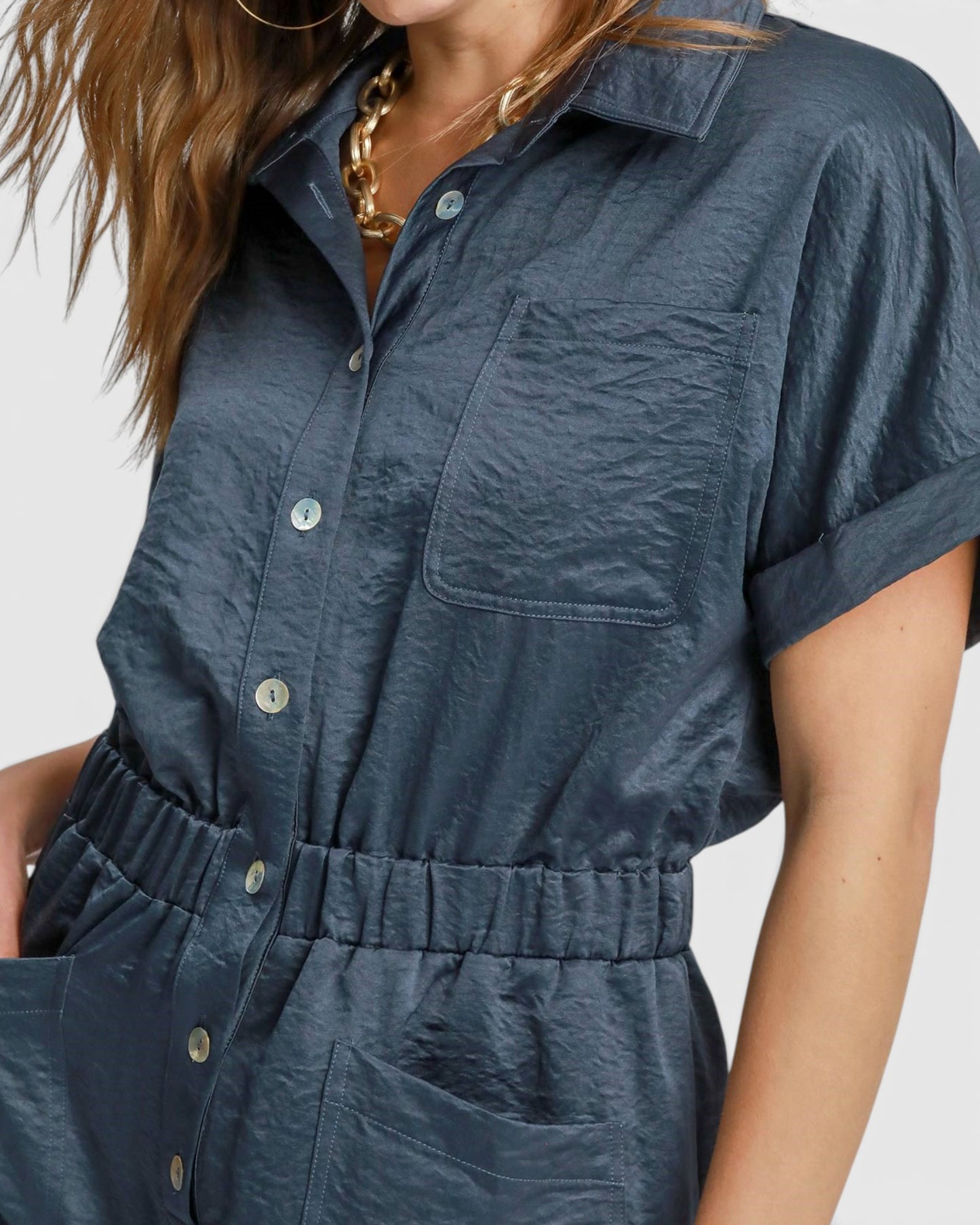 Navy blue button-up dress worn by a person on a light gray background