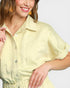 Woman wearing a light yellow dress with a plain background
