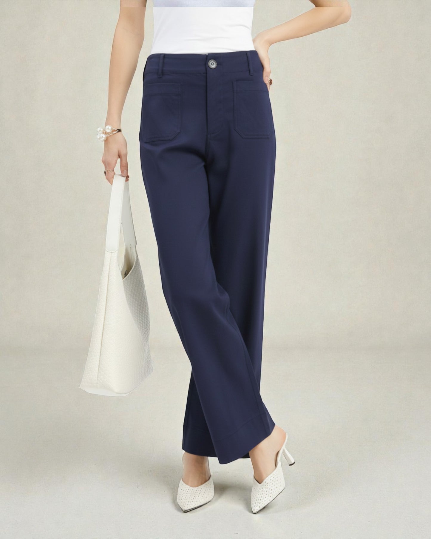 Person wearing navy blue pants with a plain background