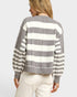 Person wearing a gray and white striped sweater on a plain background