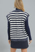 Woman wearing a navy and white striped vest over a dark blue long-sleeve shirt on a gray background