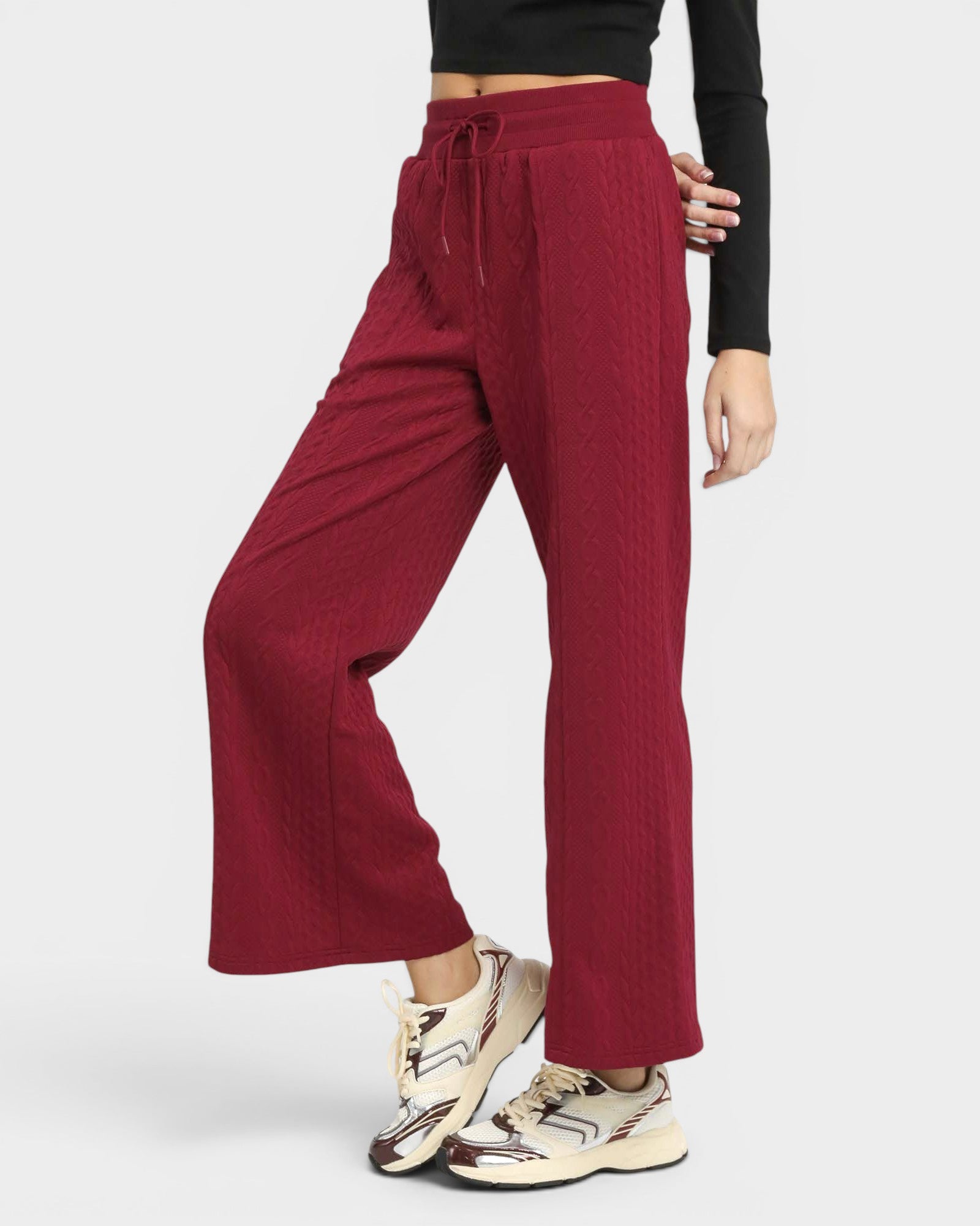 Maroon pants worn by a person on a white background