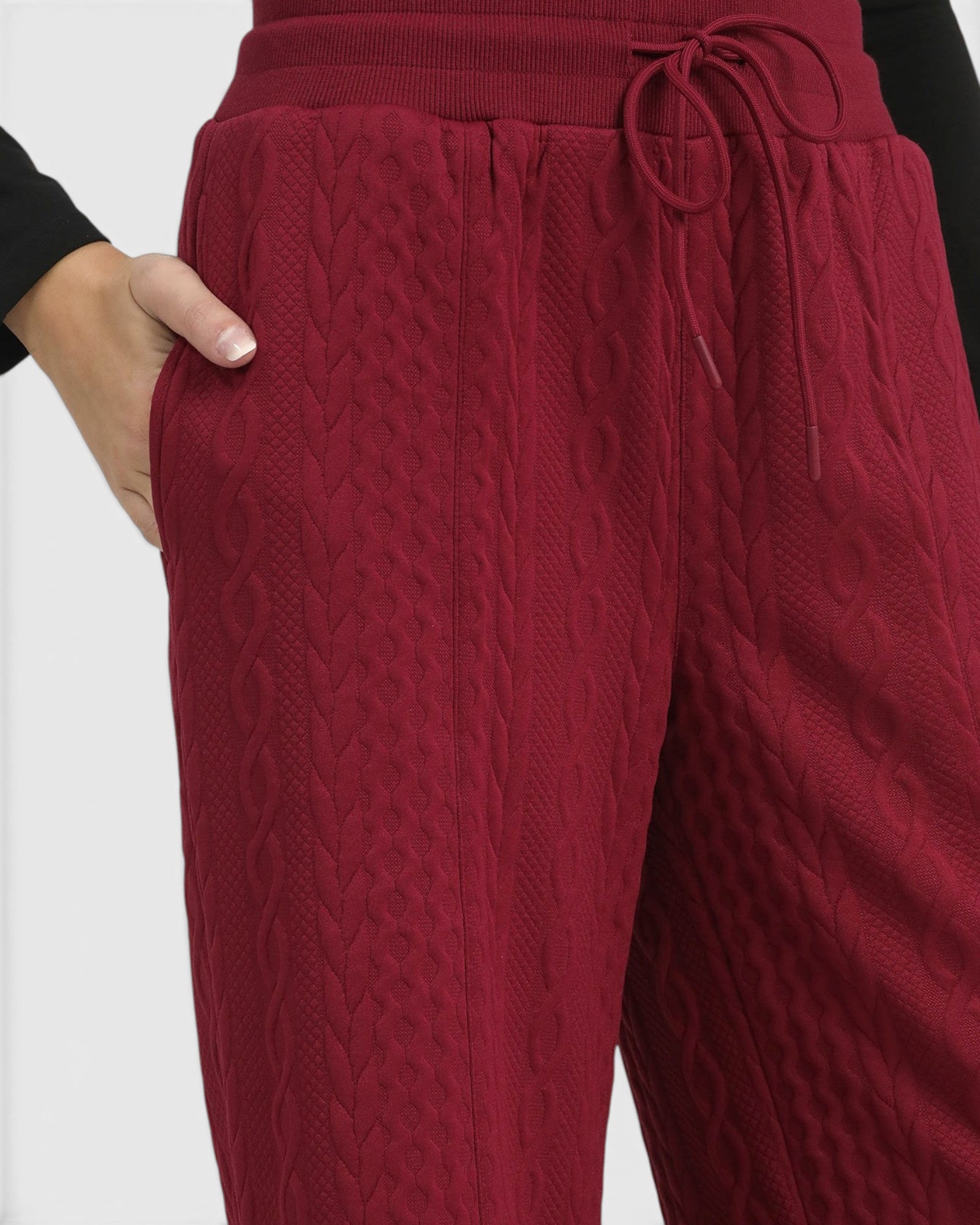 Close-up of red textured pants with a white background
