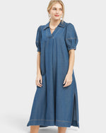 Woman wearing a blue denim dress on a white background