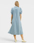 Woman wearing a light blue dress with puff sleeves on a white background