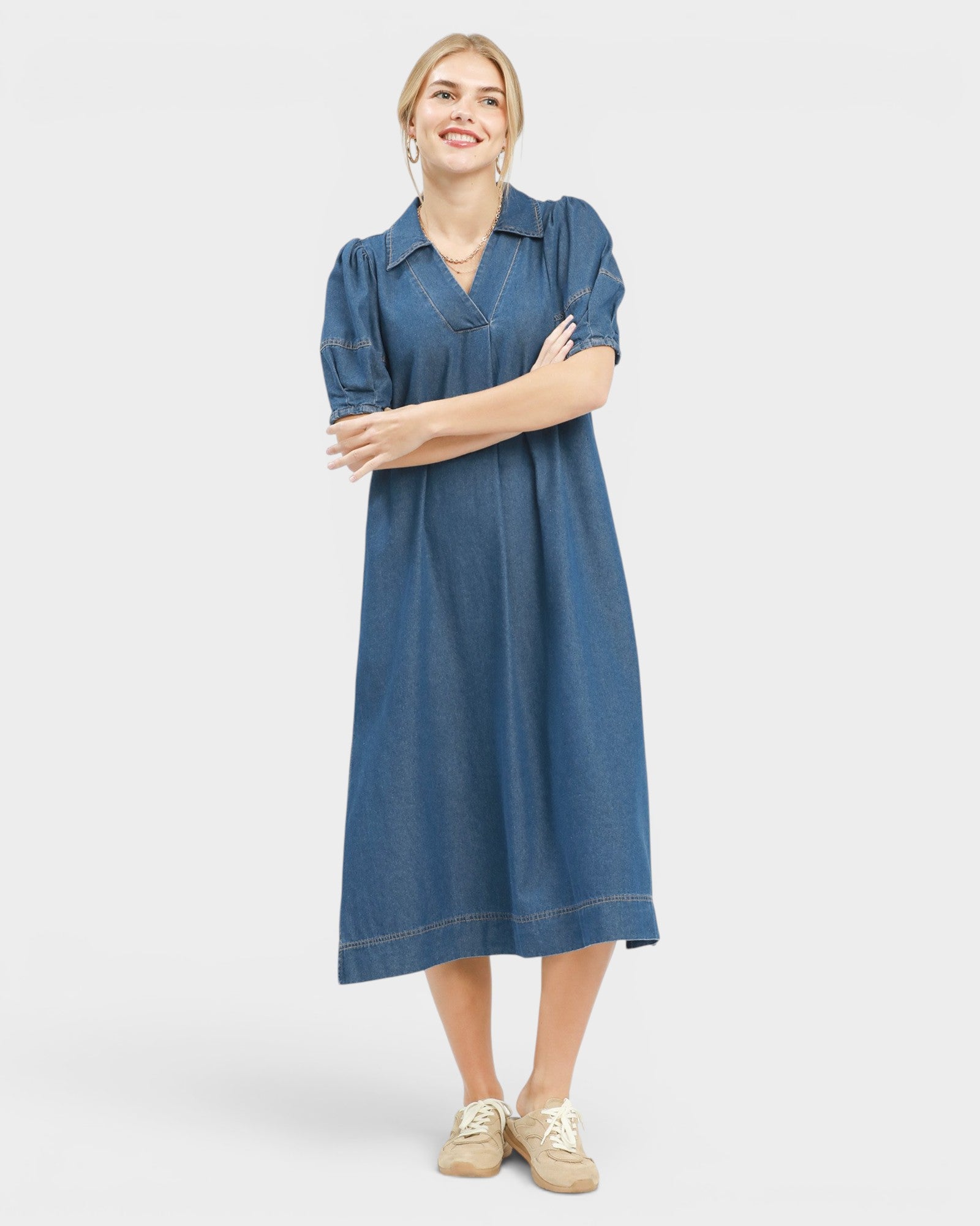 Woman wearing a blue dress with short sleeves on a white background