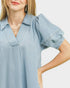 Light blue denim shirt worn by a model on a plain background