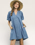 Woman wearing a blue dress and straw hat on a white background