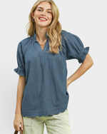 Woman wearing a blue blouse with short sleeves on a white background