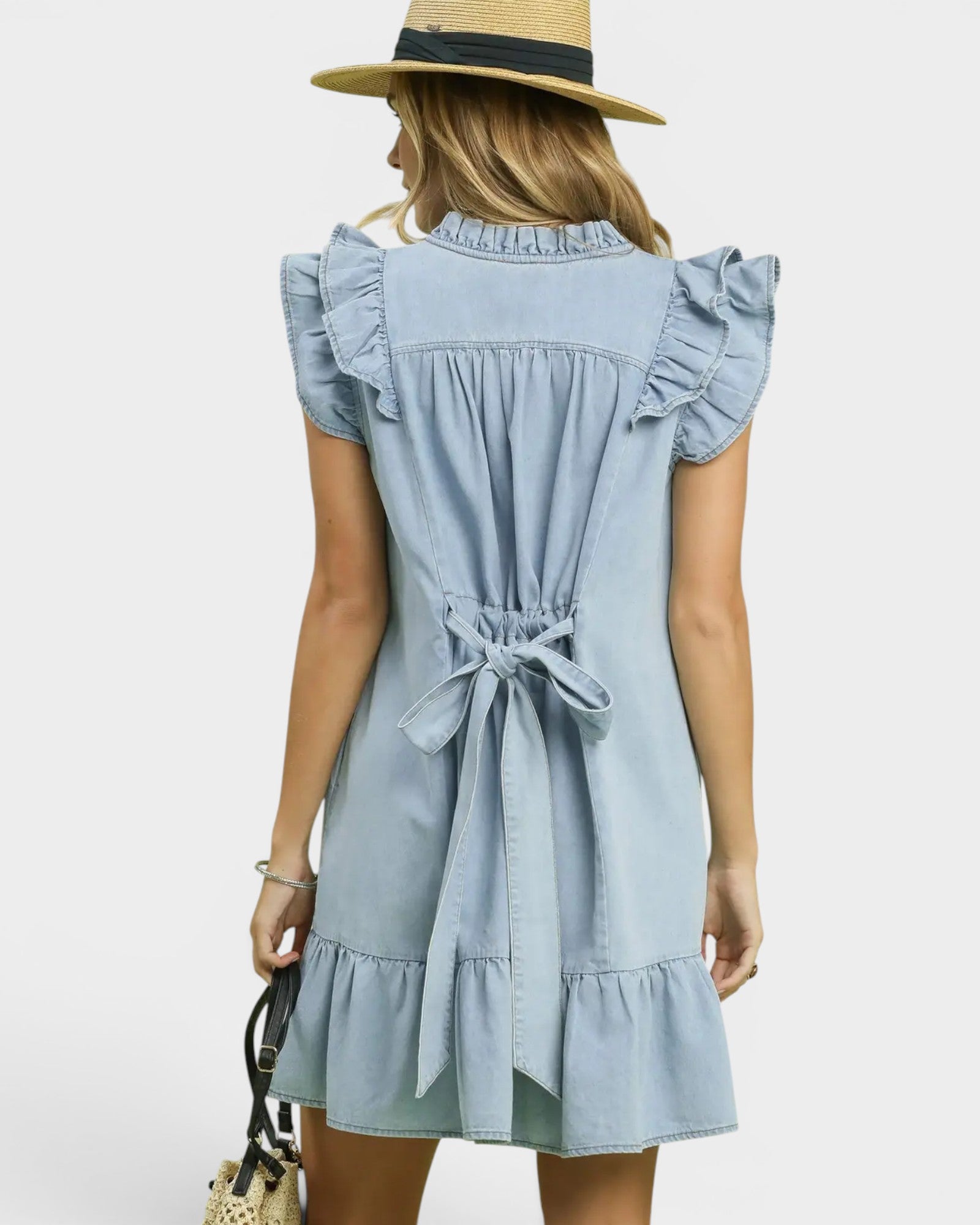 Woman wearing a light blue dress with ruffled details on a white background