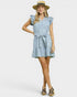 Woman wearing a light blue dress with ruffled sleeves and a belt, standing against a white background.
