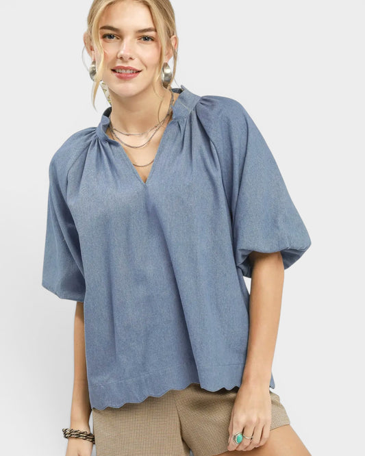 Woman wearing a blue blouse with a plain background