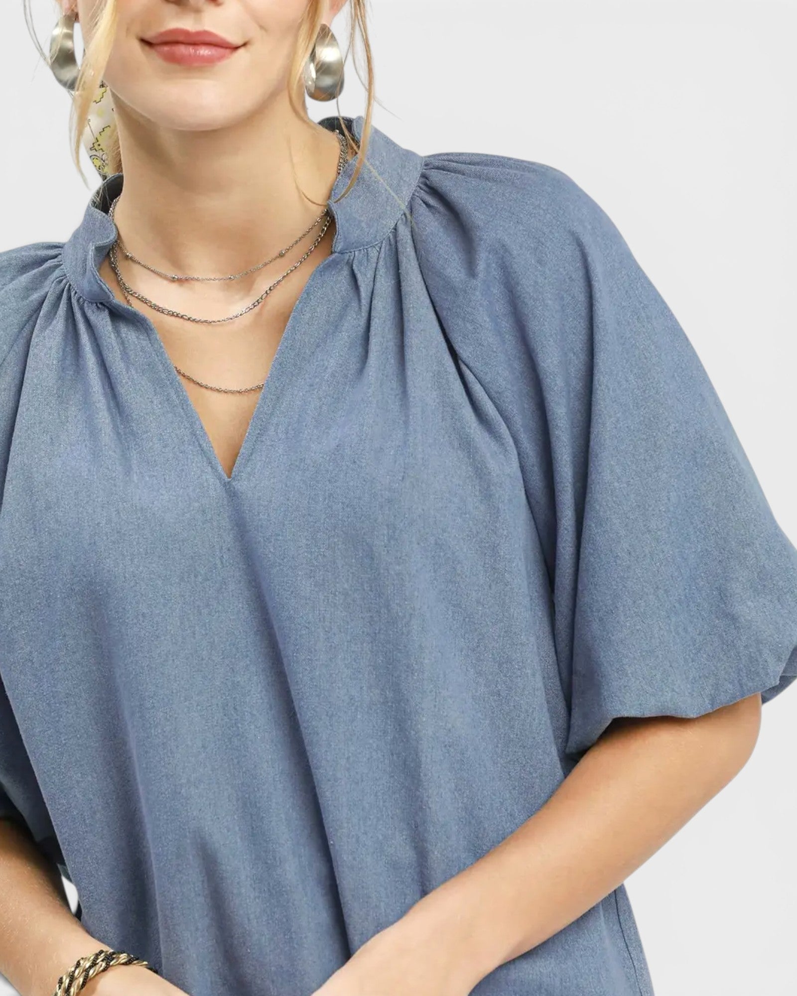 Woman wearing a blue blouse with a plain background