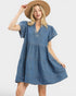 Woman wearing a blue denim dress and beige hat on a white background