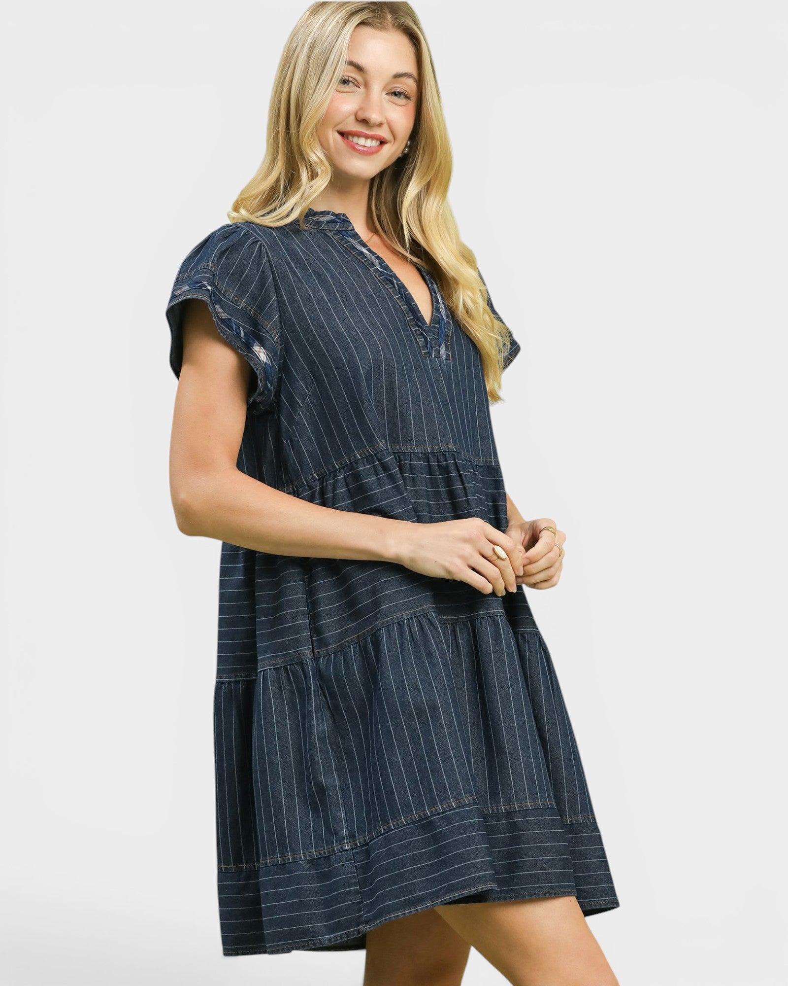Woman wearing a navy pinstripe dress on a white background
