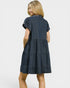 Woman wearing a blue tiered dress on a white background