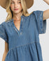 Woman wearing a blue denim dress and brown hat on a white background