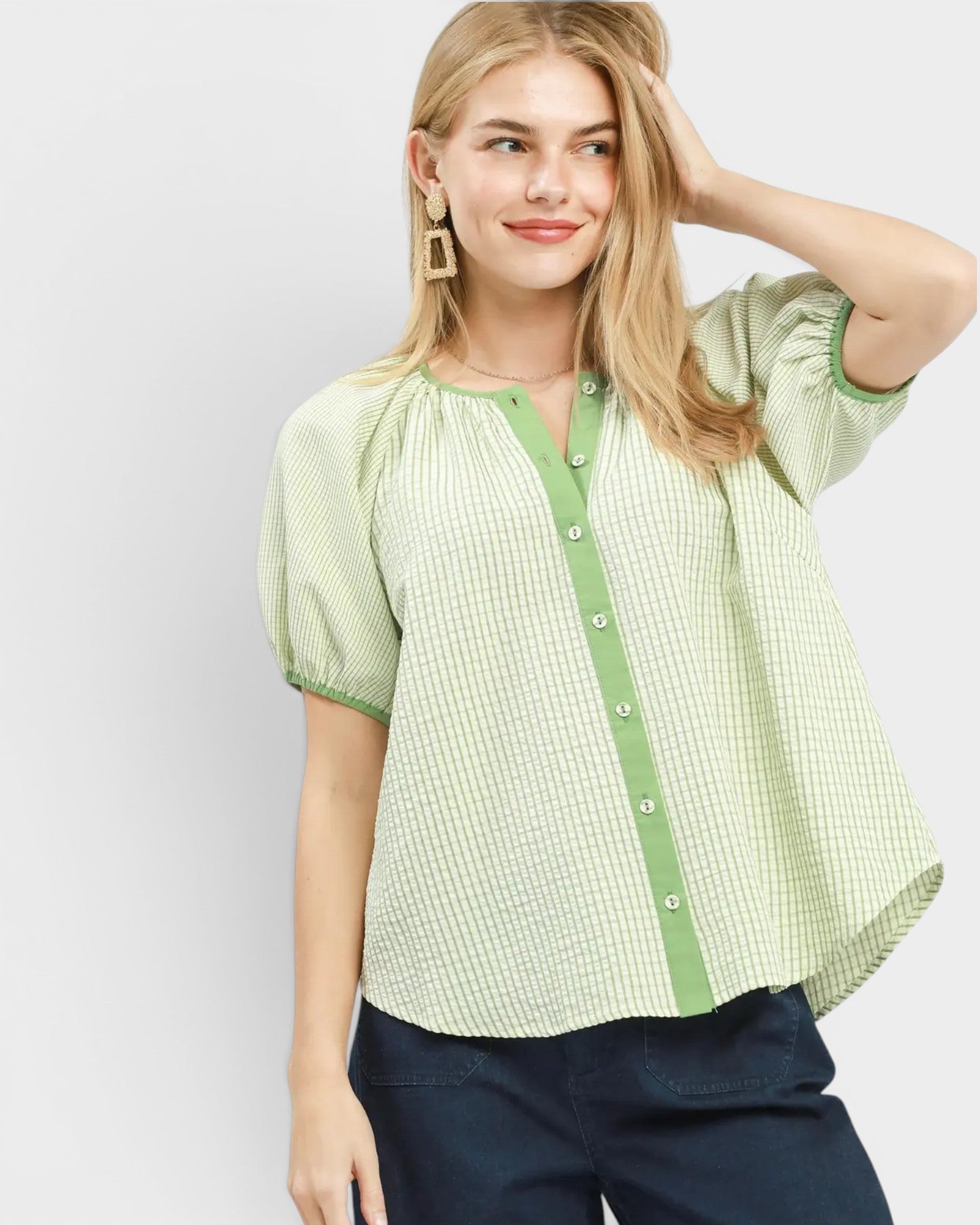 Woman wearing a green checkered blouse with a plain background