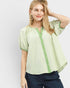 Woman wearing a green checkered blouse with a plain background