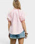 Person wearing a pink checkered blouse and blue shorts on a white background
