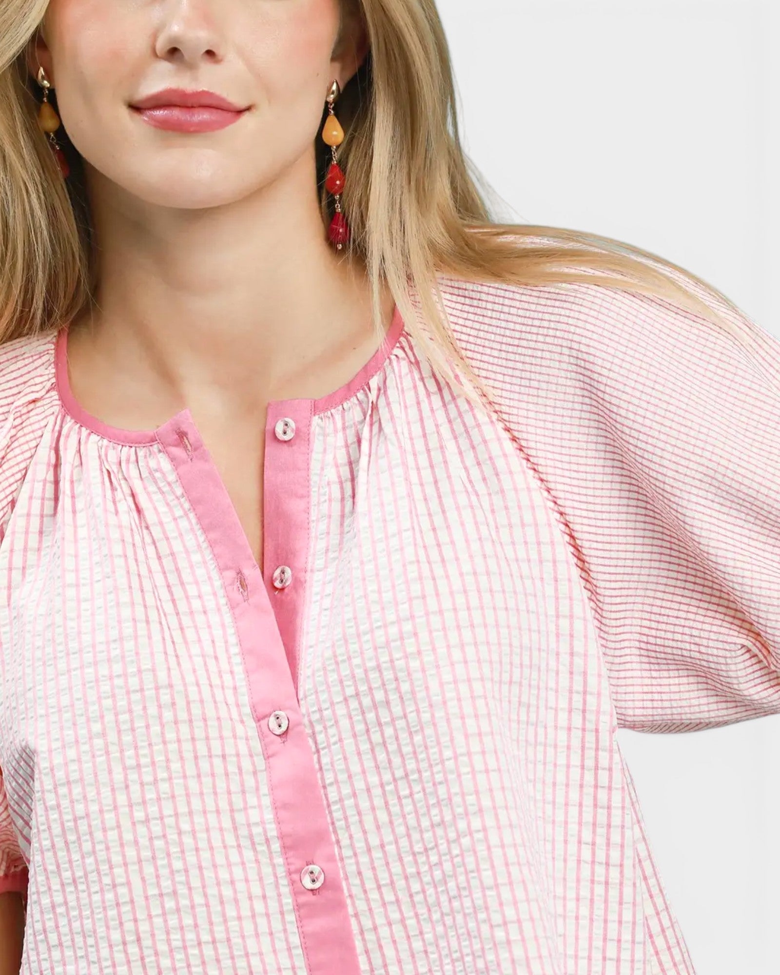 Woman wearing a pink checkered shirt on a white background