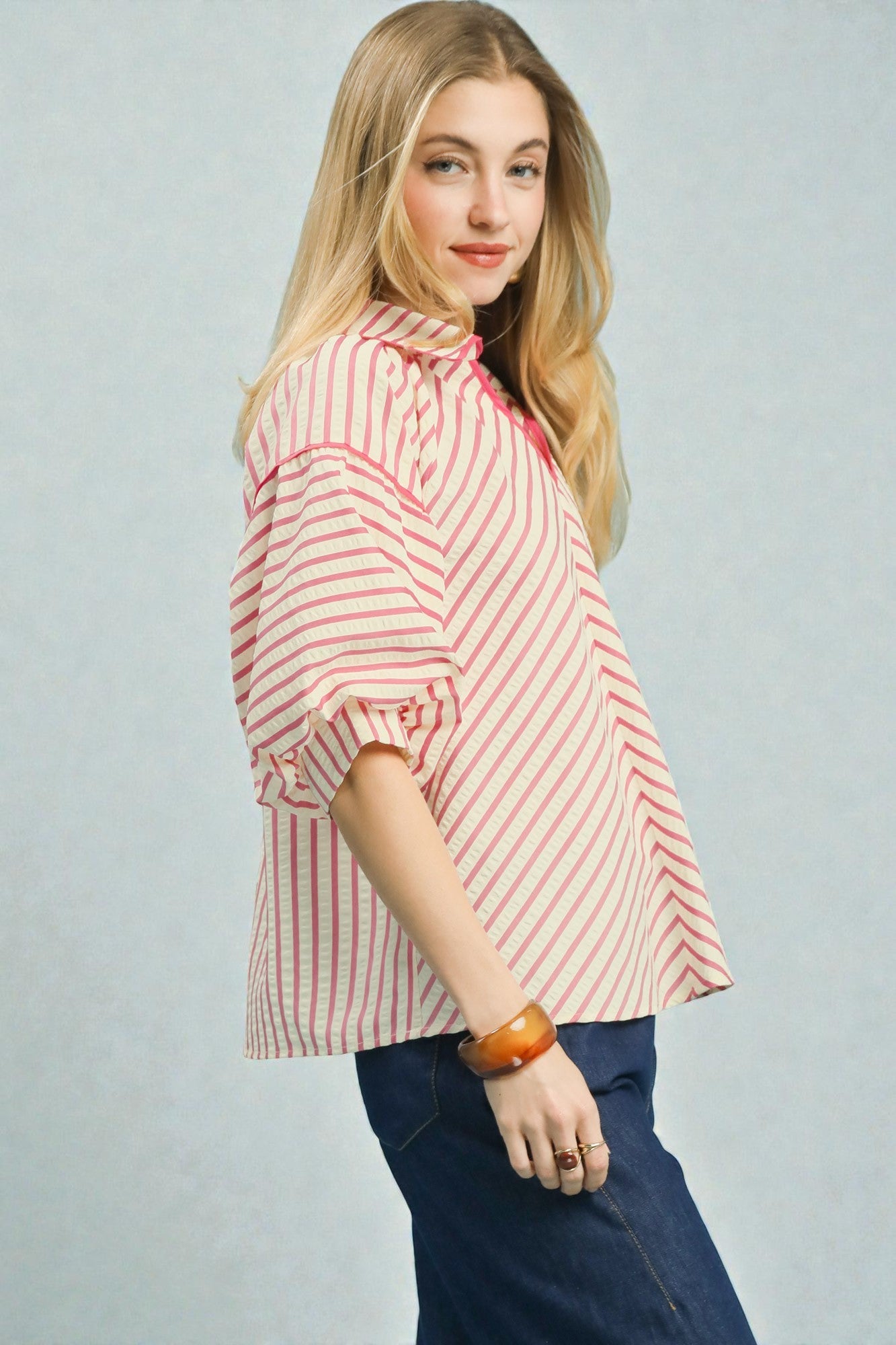 Woman wearing a red and white striped shirt against a plain background