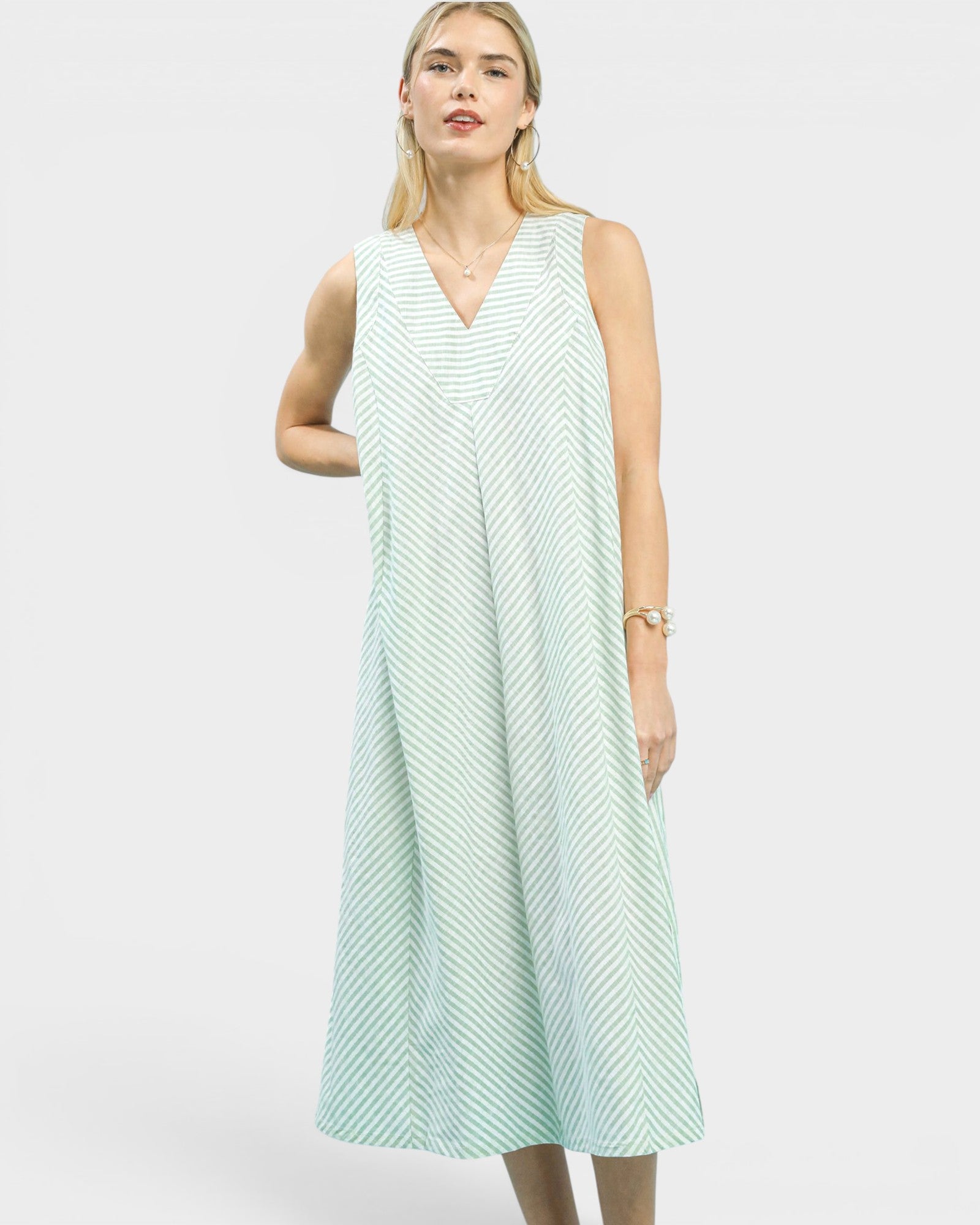Woman wearing a light green sleeveless dress on a white background