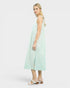 Woman wearing a light green and white striped dress on a white background