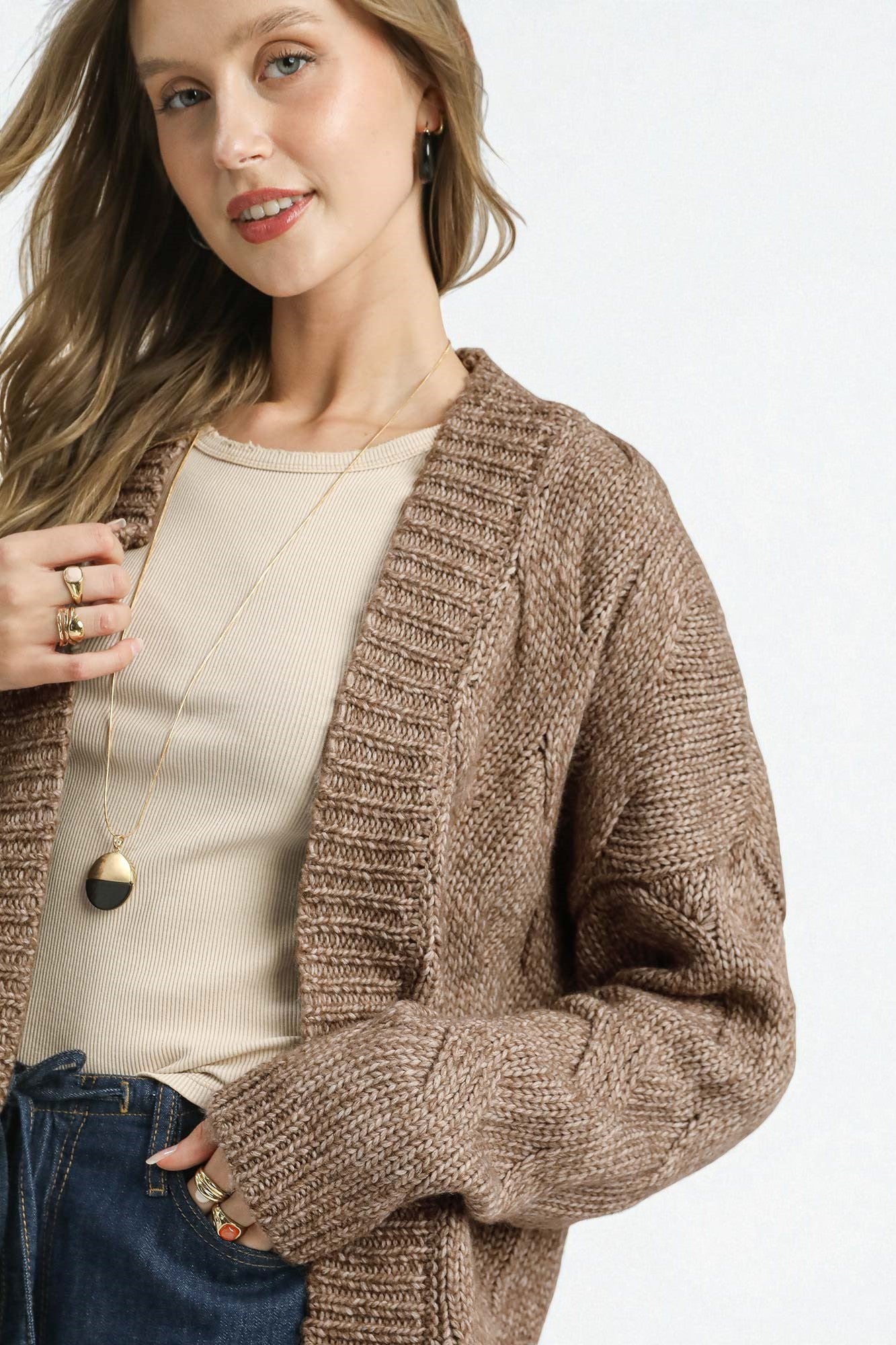 Woman wearing a brown knitted cardigan on a white background