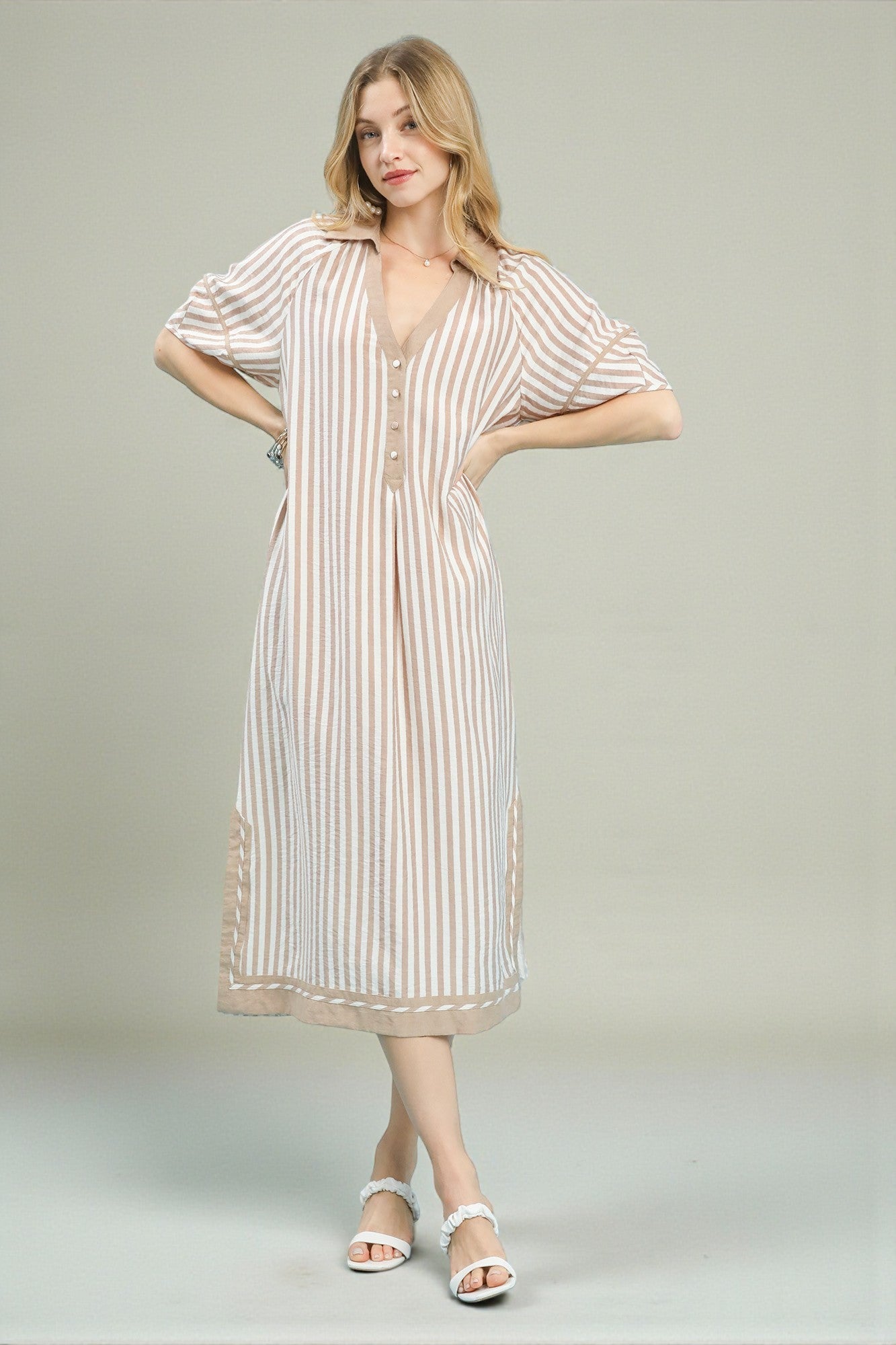 Woman wearing a striped dress on a plain background