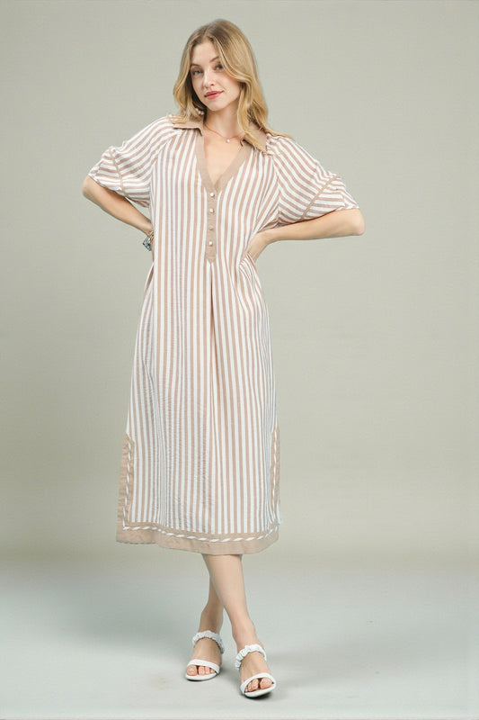 Woman wearing a striped dress on a plain background
