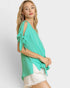 Woman wearing a green top with tied sleeves on a white background