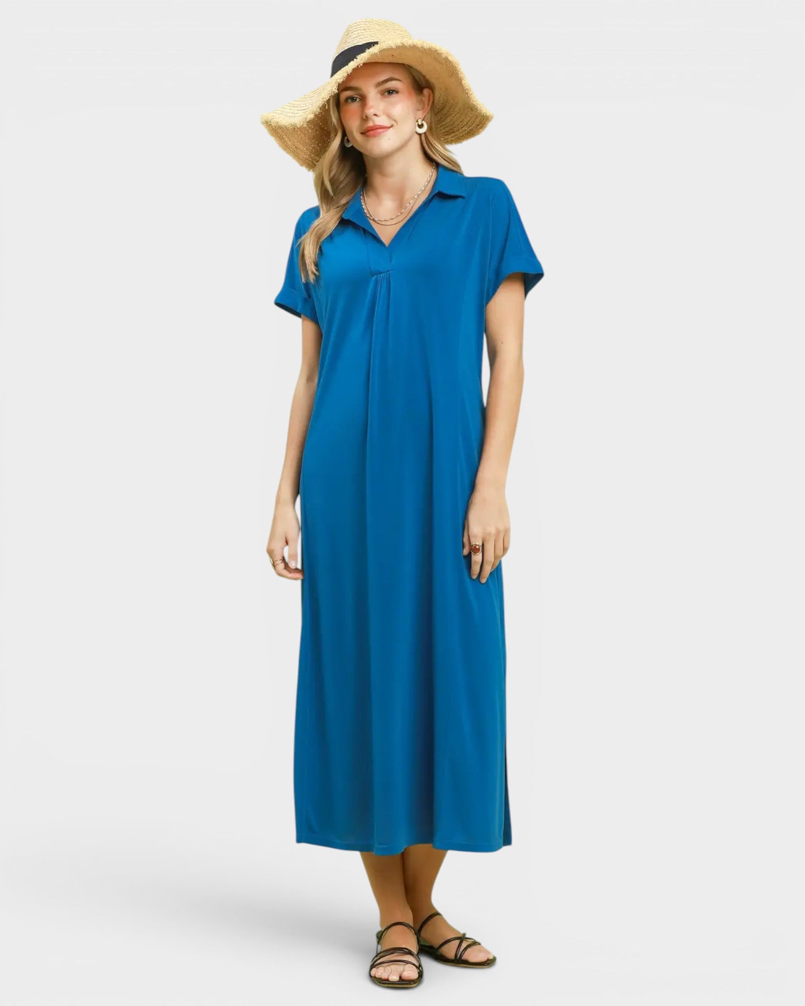 Woman wearing a blue dress and straw hat on a white background