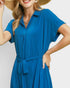 Woman wearing a blue dress with a plain background