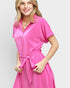 Woman wearing a pink dress against a plain background