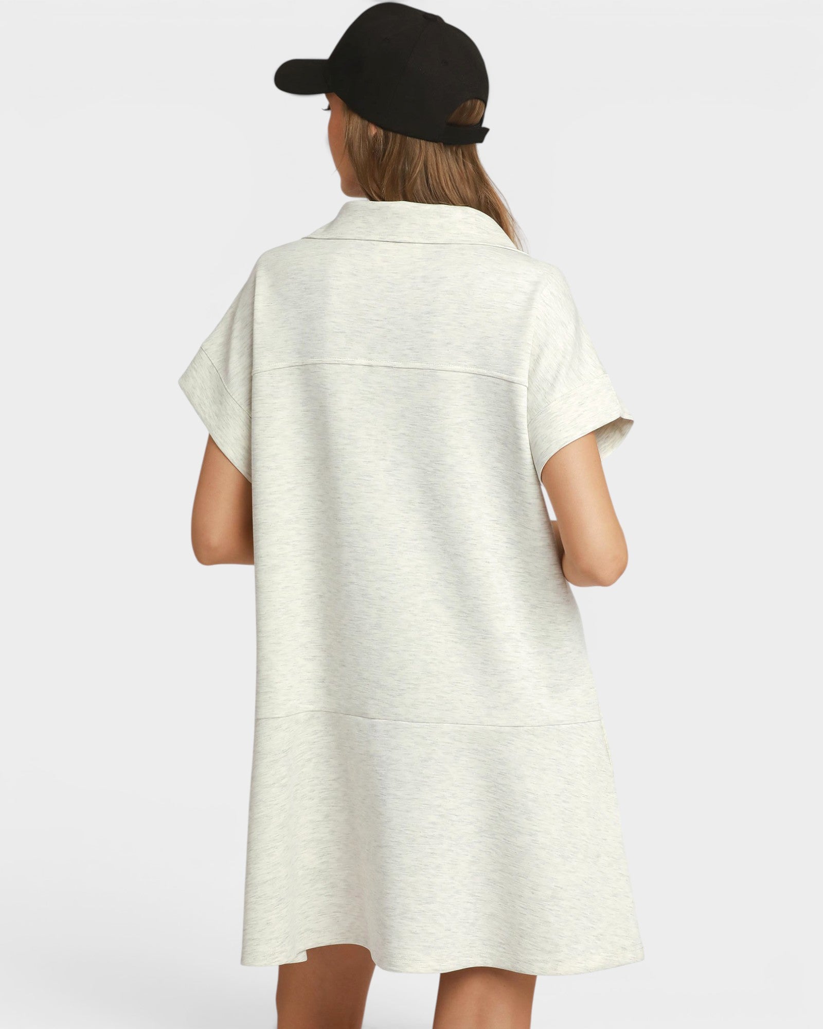 Person wearing a white dress with short sleeves on a plain background