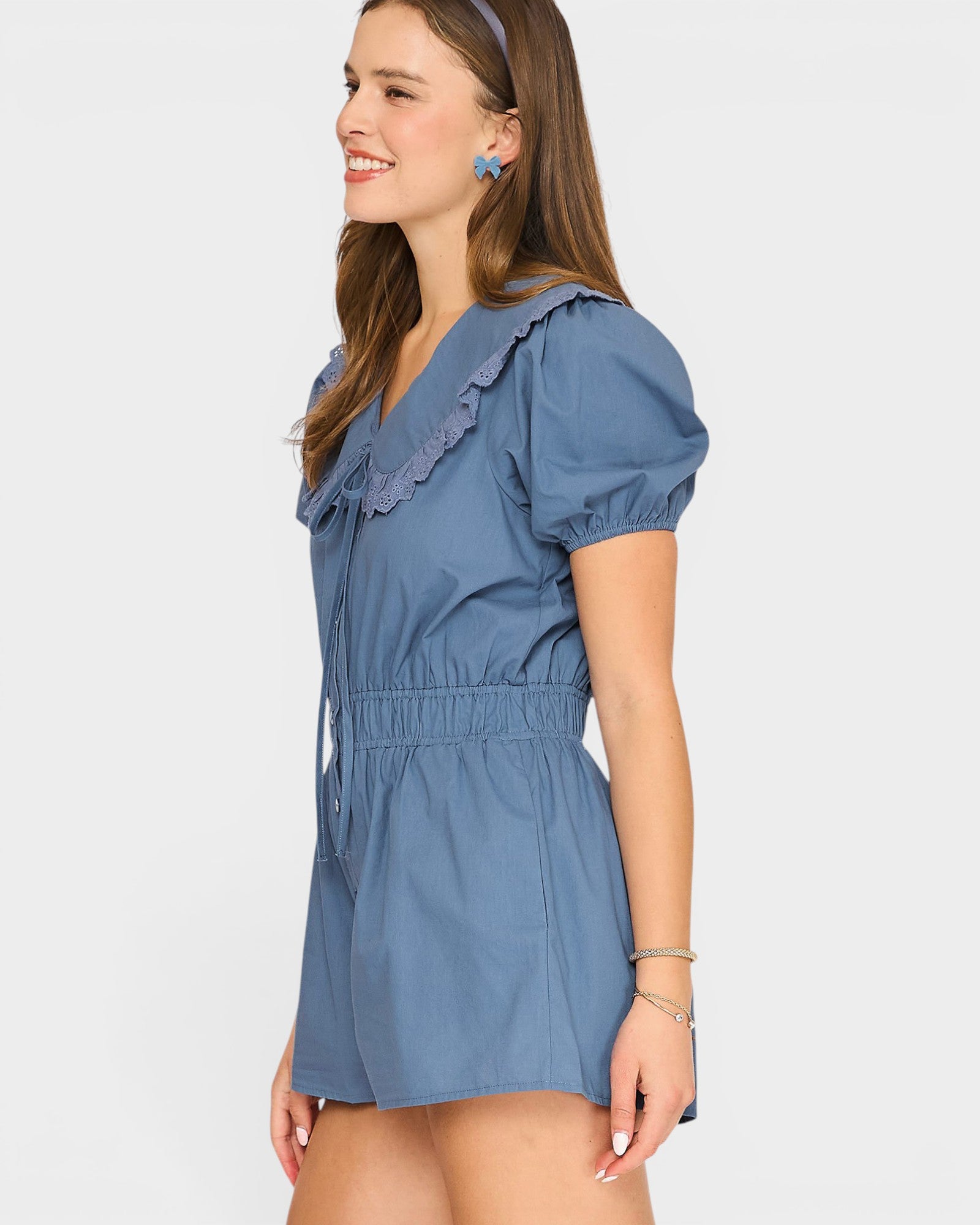 Woman wearing a blue dress with ruffled details on a white background