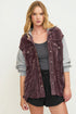 Woman wearing a purple corduroy vest over a gray shirt on a white background