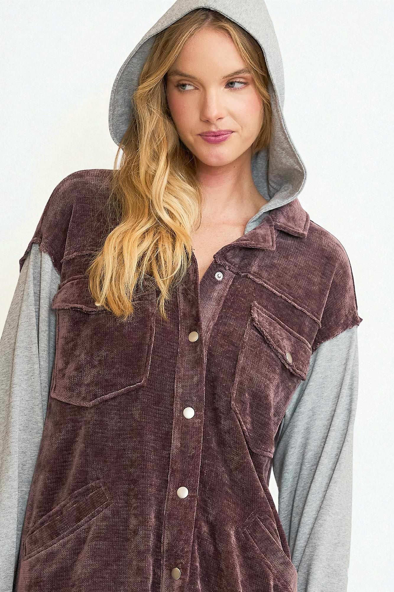 Woman wearing a brown corduroy shirt with a hood on a white background