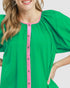 Woman wearing a green dress with pink trim on a white background