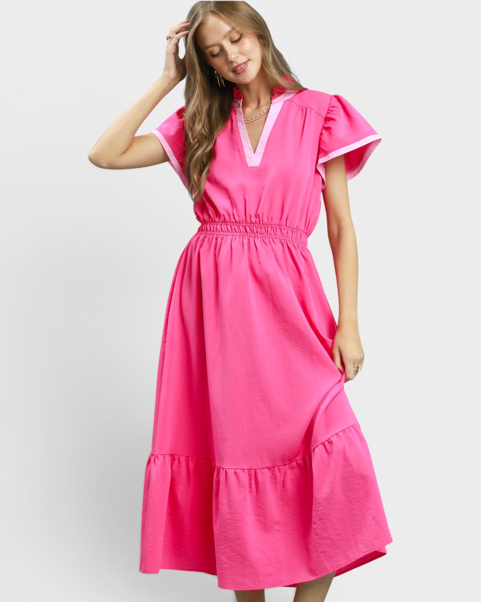 Woman wearing a bright pink dress on a white background