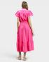 Woman wearing a bright pink dress with white trim on a light gray background