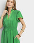 Woman wearing a green dress against a plain background